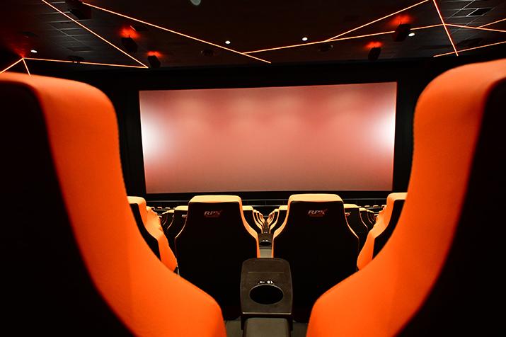 Family laughing and eating popcorn while watching a movie