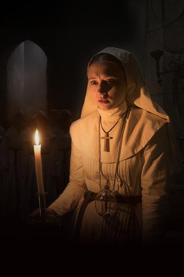 A nun holding a candle in a creepy room Mobile