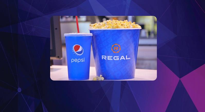 popcorn and soda on a purple background with angles that match the regal crown club card