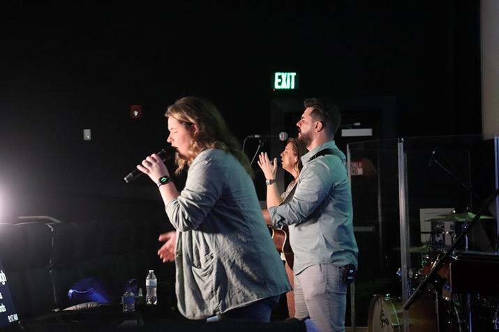 Band singing during worship service at theatre church.
