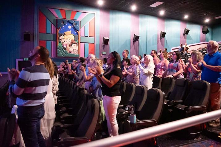 Church holding worship service in a movie theatre auditorium.
