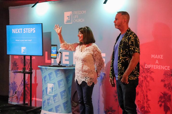 Greeters at a theatre church waving to patrons.