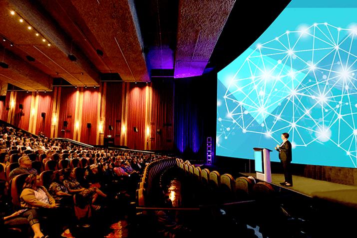 Speaker giving a business presentation in a movie theatre