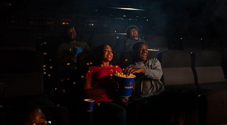 friends experiencing the movement of 4dx, popcorn is spilling everywhere